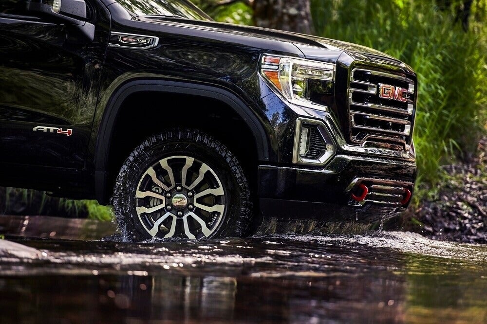 2025 GMC Sierra driving on dirt.