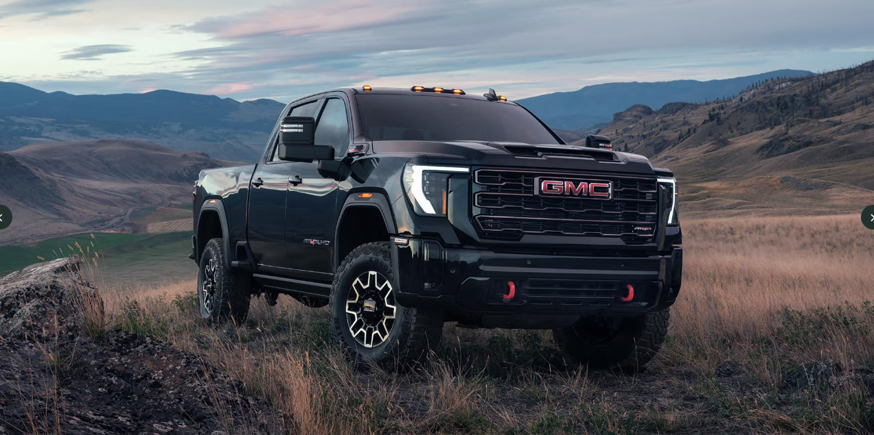 A dark blue GMC Sierra 2500 driving through a field.