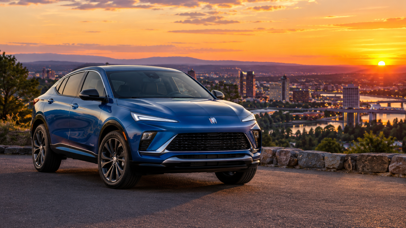 Blue Buick Envista parked at a scenic city overlook during sunset, with a glowing orange sky and panoramic city skyline in the background.