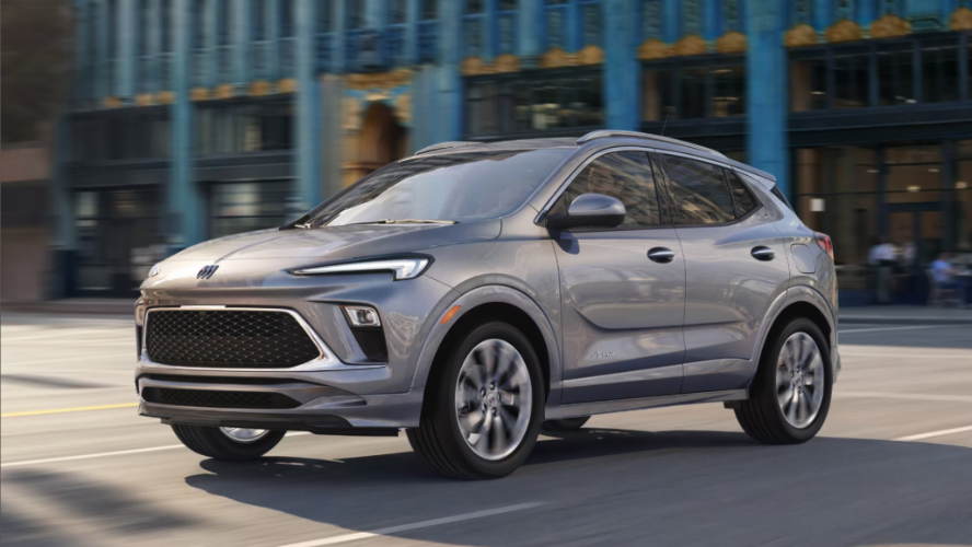 A silver Buick Encore GX driving down the road.