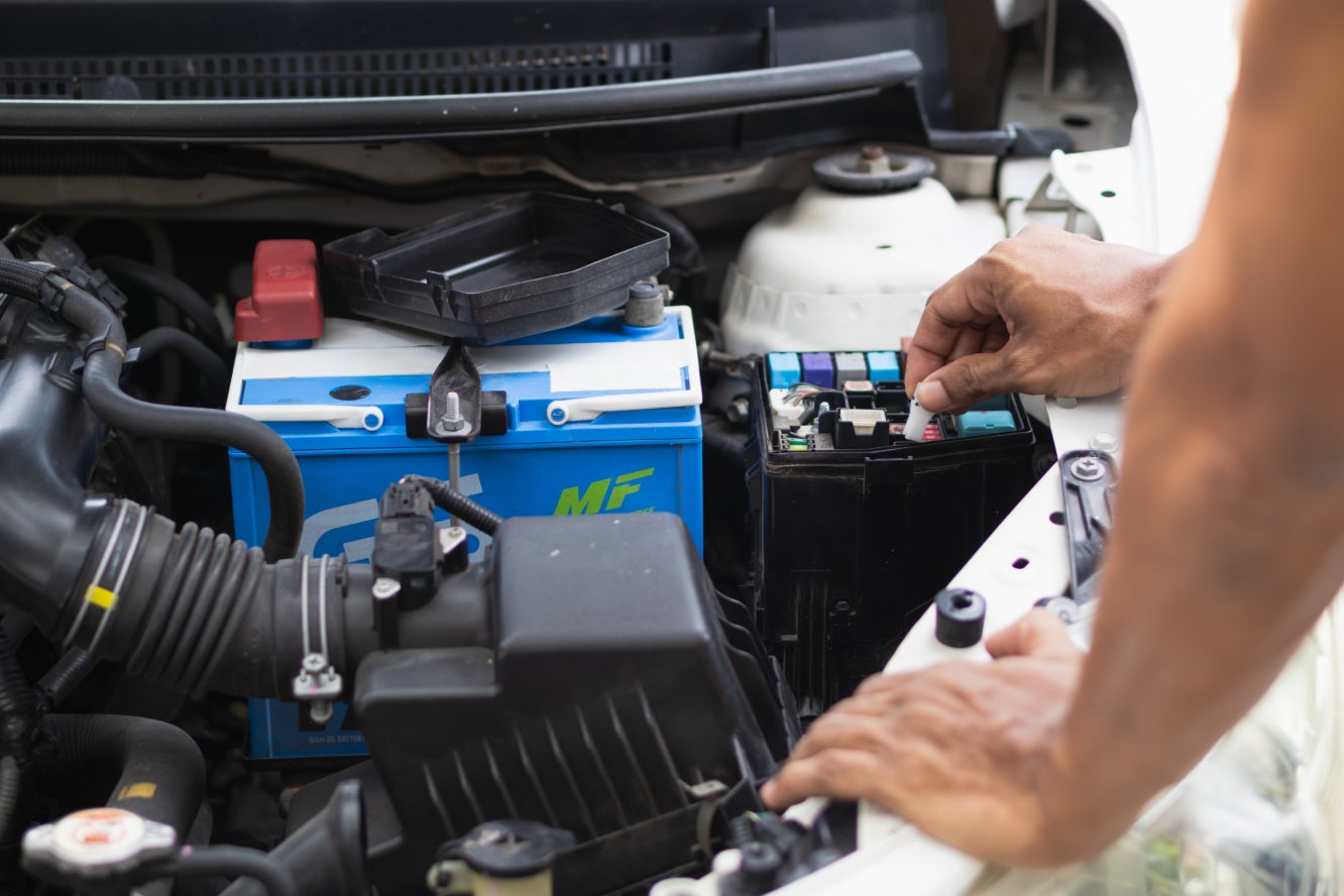 A mechanic checking a vehicle's battery.