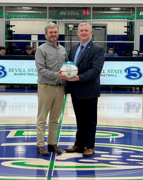 Curtis Ballard and Bevill State Community College President Joel Hagood holding a basketball at halfcourt